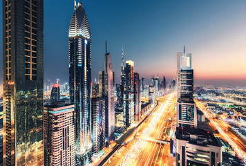 Wall Mural - Spectacular nighttime skyline of Dubai, UAE.  Futuristic architecture of a big city at night. View over the famous highway with illuminated skyscrapers. Colourful travel background.