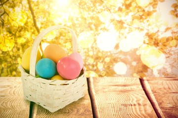 Sticker - Composite image of mulit colored easter eggs in wicker basket