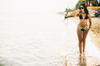 © BGStock72 - Fit and sporty woman in a swimsuit relaxing on a beach at summer