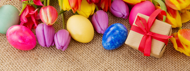  Spring tulips with colorful easter eggs and gift box.