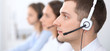 © rogerphoto - Call center operators. Focus at businessman in headset while consulting customers.