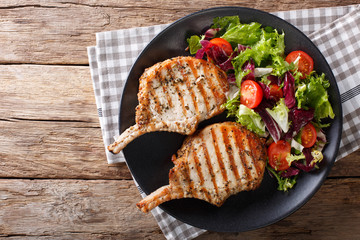 BBQ spicy pork cutlet with mixed salad on a plate close-up. horizontal top view