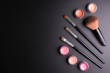 Set of flat top view of various professional female cosmetics brushes for makeup and lipstick isolated on black background, Cosmetics concept, Makeup concept, Copy space image for your text, Flat lay.