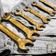 Set of golden wrenches on jeans background