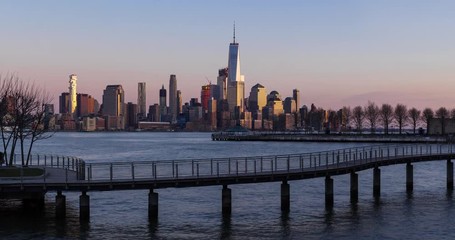 Fototapete - New York City Lower Manhattan cityscape view from Hoboken (NJ). Sunset to twilight time-lapse with piers, pedestrian bridge and skyscrapers