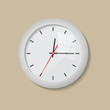 Realistic round white wall clock isolated on a beige backgound. Modern analog clock hanging on the wall.