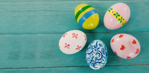 Wall Mural - Multicolored Easter eggs against wood background 