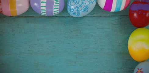 Wall Mural - Various Easter eggs arranged on wooden surface