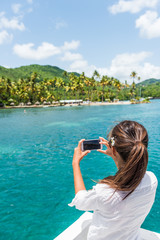 Woman on shore excursion boat tour taking phone pictures of popular tourist attraction in St Lucia. Famous beach in Anse Chastanet, Caribbean island.