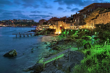 Southern Fortress Wall And Tower Of The Old Town Of Sozopol (former Ancient Town Of Apollonia) With Yellow-green Illumination In Twilight, Bulgaria. Sozopol Is The Famous Resort On The Black Sea Coast