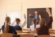 © Africa Studio - Pupils listening teacher and raising hands to answer in classroom