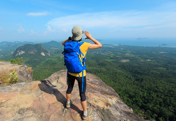 successful woman hiker shouting hiking on mountain peak
