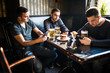 © F8  \ Suport Ukraine - Male friends sitting in smartphones drinking beer at bar or pub. Smartphones social network dependence.