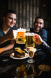 © F8  \ Suport Ukraine - Friends drinking beer and clinking glasses at bar or pub