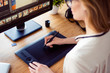 © deagreez - Back view of graphic designer working with interactive pen display, digital drawing tablet and pen on a computer in workstation