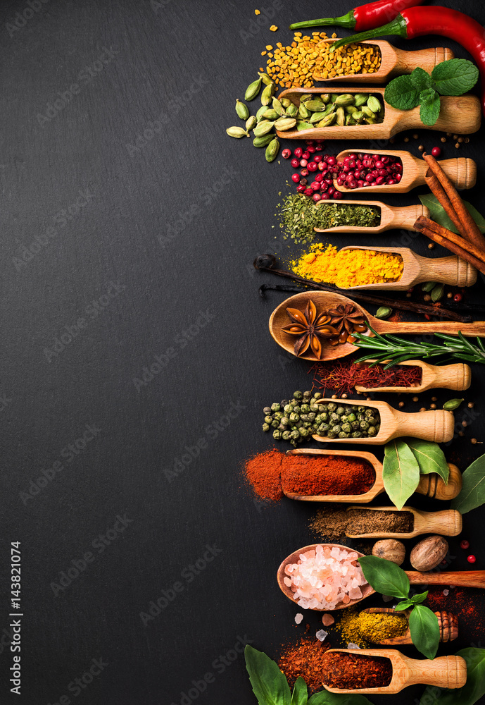 Photo Background with various spices on black slate. Top view