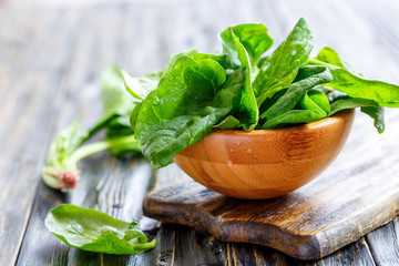 Wall Mural - Fresh spinach in a wooden bowl.