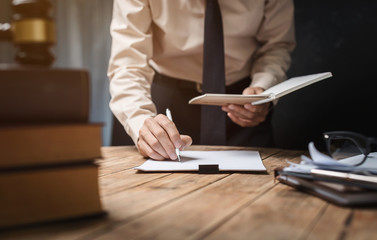 Business lawyer working hard at office desk workplace with book and documents.