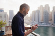 © phocal Media - Man messaging on mobile at balcony.