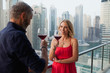 © phocal Media - Couple drinking wine at balcony.