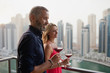 © phocal Media - Couple drinking wine at balcony.
