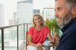 © phocal Media - Couple relaxing at balcony.
