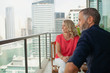 © phocal Media - Couple looking out from balcony.