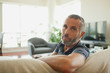 © phocal Media - Portrait of man leaning on couch.