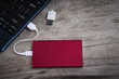 © NAMPIX - Red external hard drive (HDD) connected to laptop
