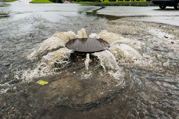 accident sewerage system. water flows over the road from the sewer. .
