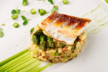 Wall Mural - Fine dining, fish fillet breaded in herbs and spice on asparagus risotto.