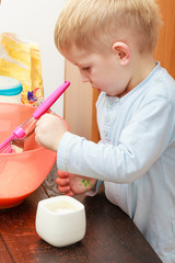 Little kid boy cooking, making cake in bowl