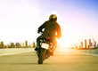 rear view of man riding motorcycle on urban traffic road for people leisure traveling theme