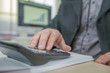 © StockVideoFactory - A businessman is typing on the calculator in his office.