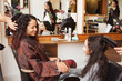 © Connect Images - Girl and mother holding hands while having their hair styled in hair salon