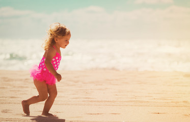 happy little girl running on beach