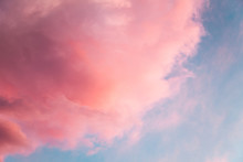 Beautiful Sky Background With Pink Fluffy Colored Cloud Looks Like Cotton Candy Or Candy-floss At Sunset With Sun Setting Down.
