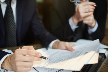 Sticker - Closeup shot of unrecognizable businessman reading contract documentation at meeting with financial partner