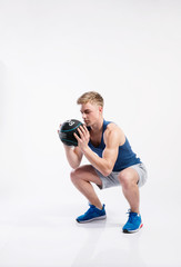 Sticker - Handsome fitness man holding medicine ball, studio shot.