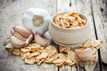 Dried garlic flakes or garlic chips and raw garlic bulb