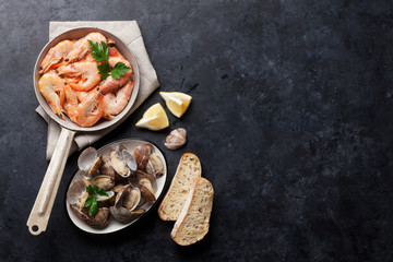 Fresh seafood on stone table. Scallops and shrimps