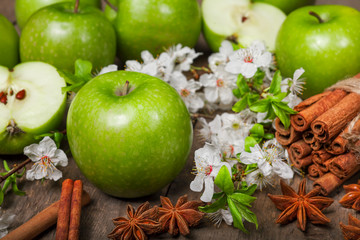 Wall Mural - Green apples, cinnamon on a wooden background