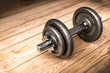 © Nitiphonphat - Dumbbells , weight plates on wooden background for bodybuilder. Concept for sport player or workout. gym of accessories for fitness