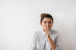 © shurkin_son - Portrait of funny young Caucasian woman in white shirt with hair bun looking seriously at the camera, holding index finger at lips, asking to keep silence or not tell anyone her secret, saying 'Tsss'