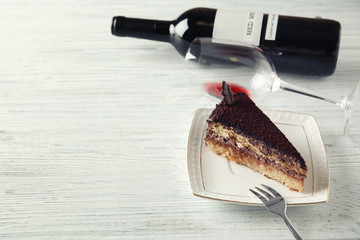 Sticker - Delicious chocolate cake and red wine on white wooden table