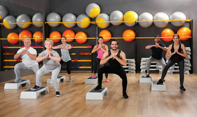 Canvas Print - People of different ages training in gym