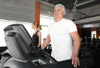 Canvas Print - Senior man running on treadmill in gym