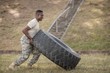 Determined military soldiers exercising with tire