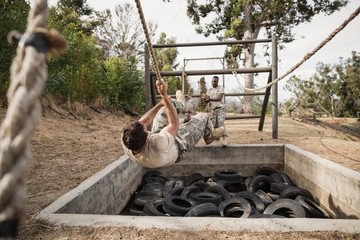 Wall Mural - Young military soldiers practicing rope climbing 