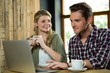 © WavebreakMediaMicro - Woman looking at man using laptop in coffee shop